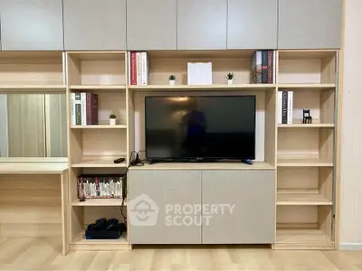 Modern living room with sleek built-in shelving and flat-screen TV, perfect for stylish entertainment setup.