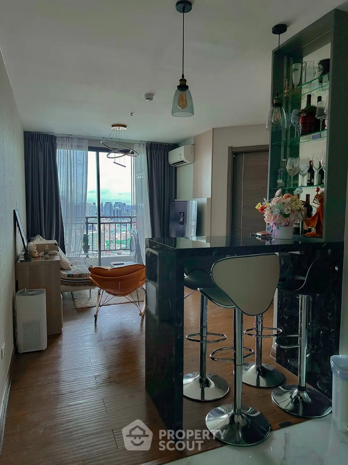 Modern living room with stylish bar counter and city view balcony, perfect for urban living.