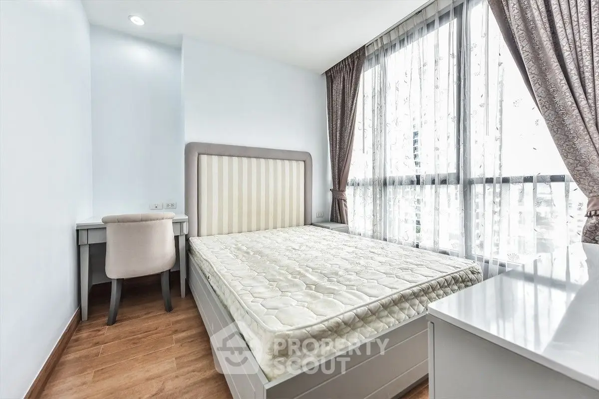 Bright and airy bedroom with large windows and elegant furnishings