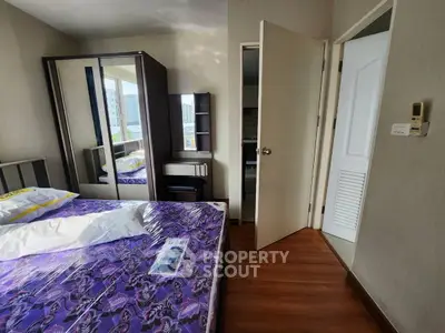 Cozy bedroom with mirrored wardrobe and wooden flooring in modern apartment.