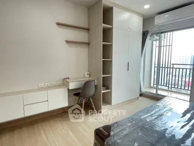 Modern bedroom with balcony view, featuring built-in desk and storage, ideal for urban living.