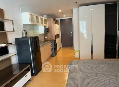 Modern studio apartment with sleek kitchen and cozy living area, perfect for urban living.