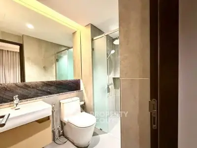 Modern bathroom with glass shower and sleek fixtures in a contemporary apartment.