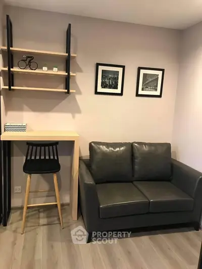 Modern living room with sleek black sofa and stylish decor in cozy apartment.