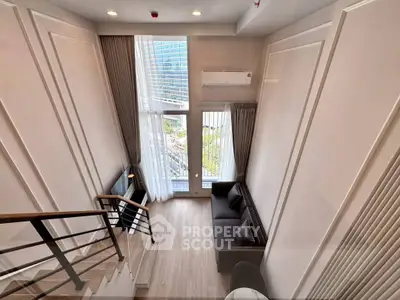 Modern loft-style living room with high ceilings and large windows