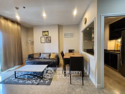 Modern living room with dining area and kitchen, featuring stylish decor and ample natural light.