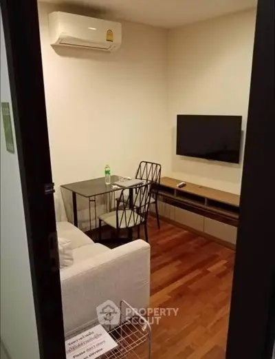Cozy living room with modern furniture and wall-mounted TV, perfect for relaxation.