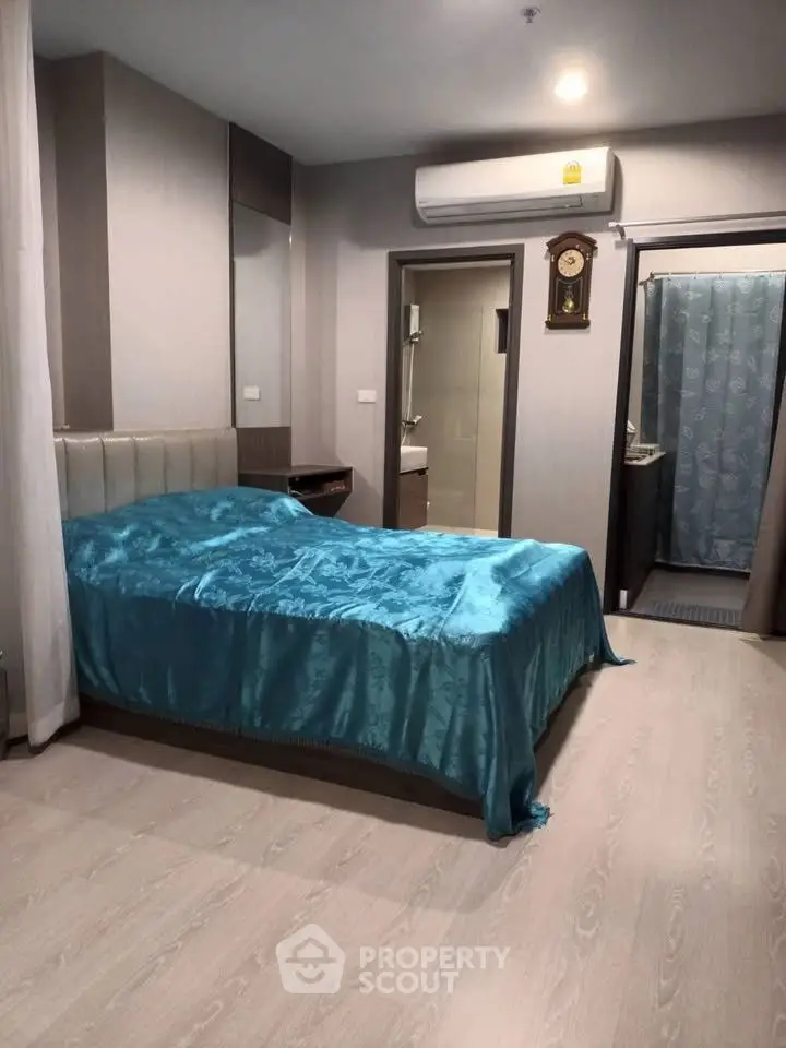 Cozy bedroom with modern decor and attached bathroom in a stylish apartment.