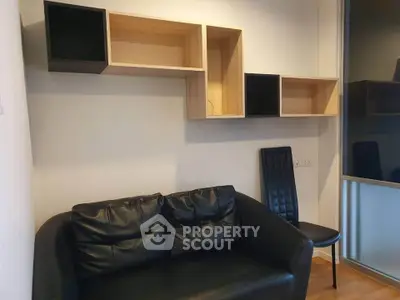 Modern living room with sleek black leather sofa and stylish wall-mounted shelves.