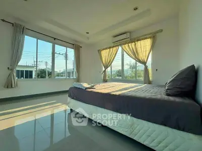 Spacious bedroom with large windows and natural light in modern home