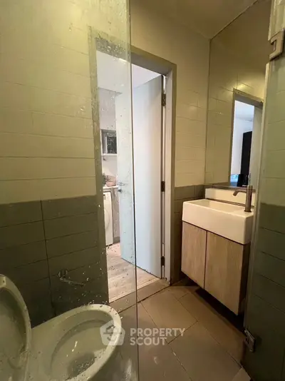Modern bathroom with sleek design and adjacent laundry area in contemporary apartment.