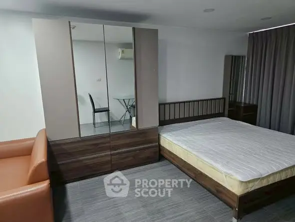 Modern bedroom with sleek furniture and minimalist design, featuring a comfortable bed and stylish wardrobe.