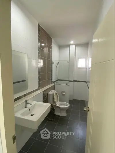 Modern bathroom with sleek design, featuring a glass shower and stylish fixtures.