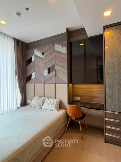 Modern bedroom with stylish wood paneling and built-in desk, featuring a cozy bed and elegant lighting.