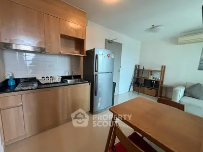 Modern kitchen with wooden cabinets and dining area in a cozy apartment.
