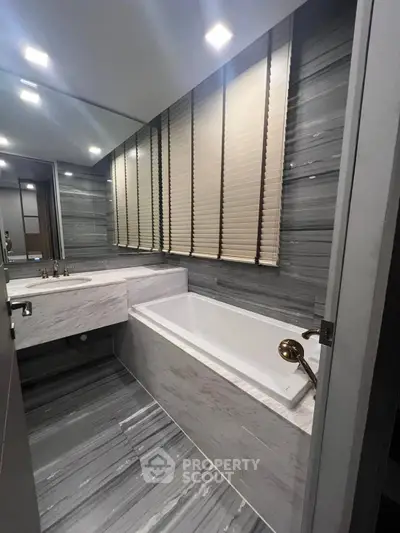 Luxurious modern bathroom with sleek marble design and elegant bathtub.