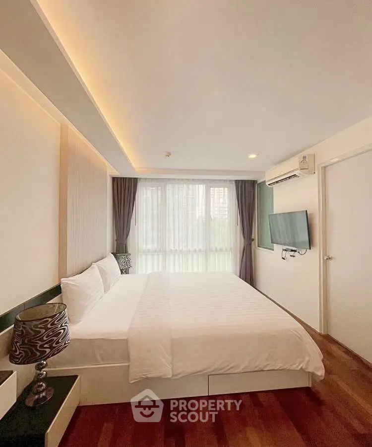Spacious bedroom with modern decor and natural light in a stylish apartment.