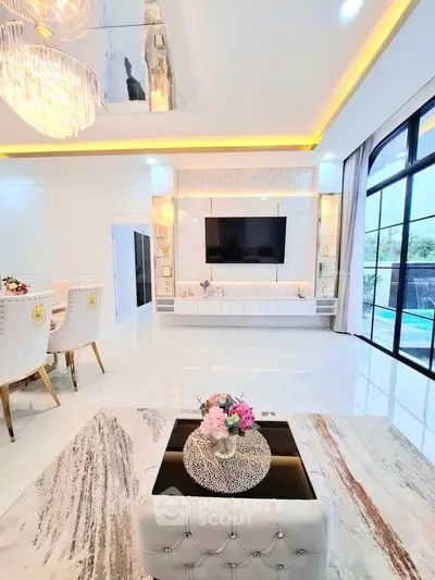 Luxurious modern living room with elegant decor and large windows overlooking a pool.