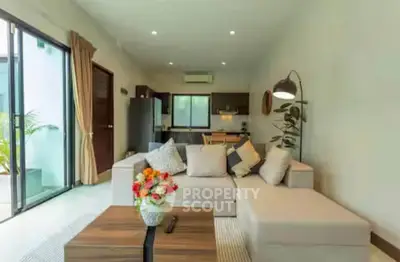 Spacious living room with modern decor and open kitchen layout, perfect for entertaining.