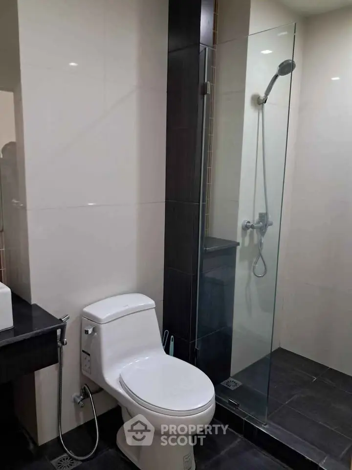 Modern bathroom with sleek glass shower and contemporary fixtures.