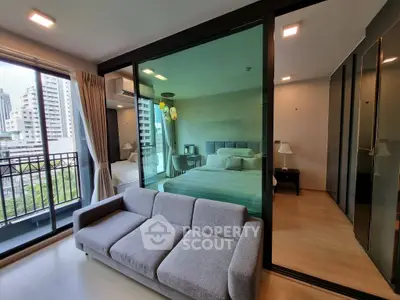 Modern condo interior with glass-walled bedroom and city view balcony.
