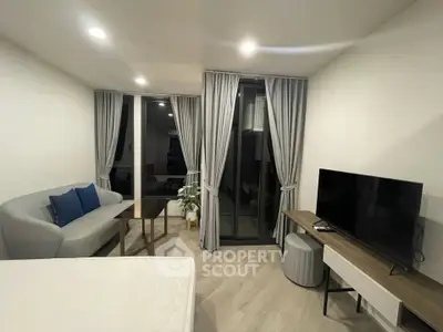Modern living room with sleek furniture and large TV, featuring floor-to-ceiling windows and elegant curtains.