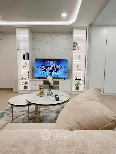 Luxurious living room with modern decor, built-in shelves, and a cozy sofa facing a flat-screen TV.