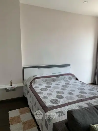 Cozy bedroom with modern decor and stylish bedding in a well-lit apartment.