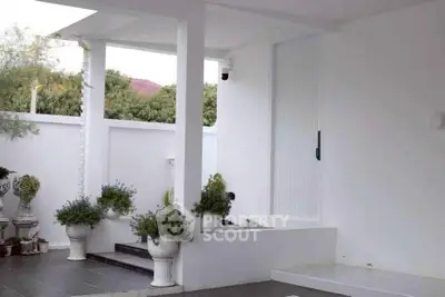 Elegant modern entrance with white pillars and potted plants