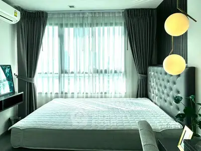 Modern bedroom with large window, stylish lighting, and elegant decor