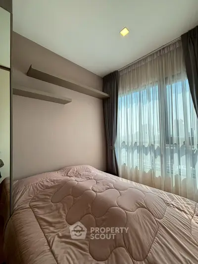 Cozy bedroom with large window and elegant curtains, featuring a comfortable bed and modern shelving.