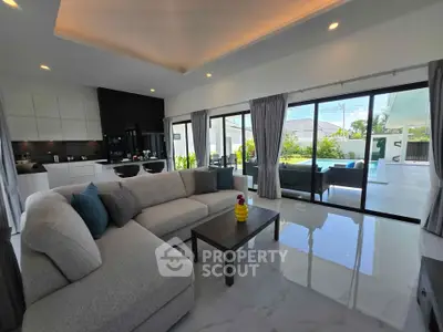 Spacious modern living room with open kitchen and large sliding doors to patio.