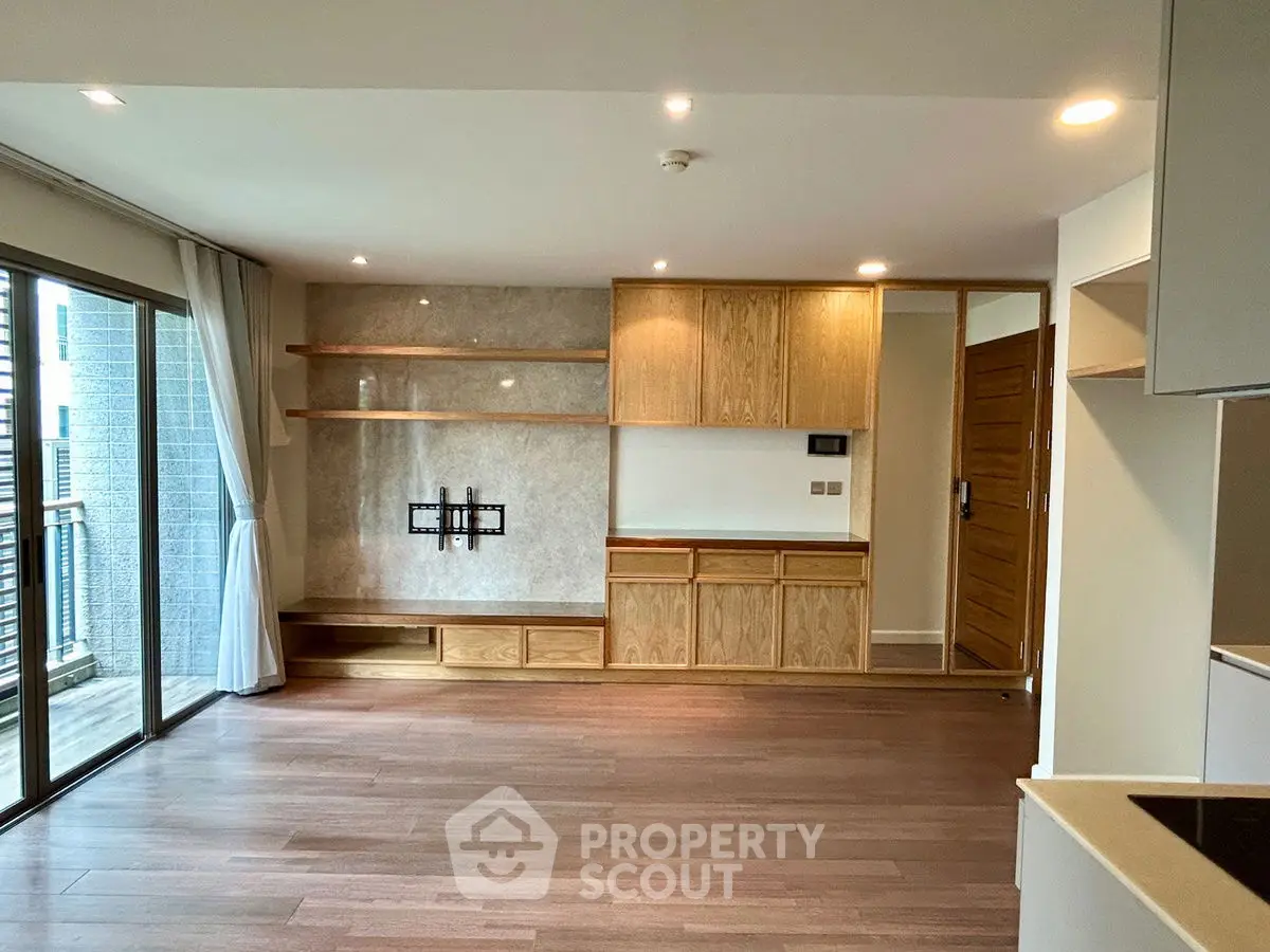 Spacious modern living room with wooden flooring and built-in shelving