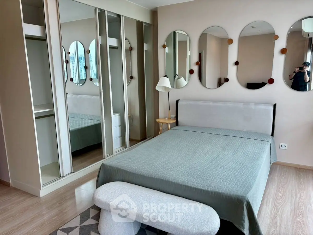 Modern bedroom with stylish mirrors and spacious wardrobe