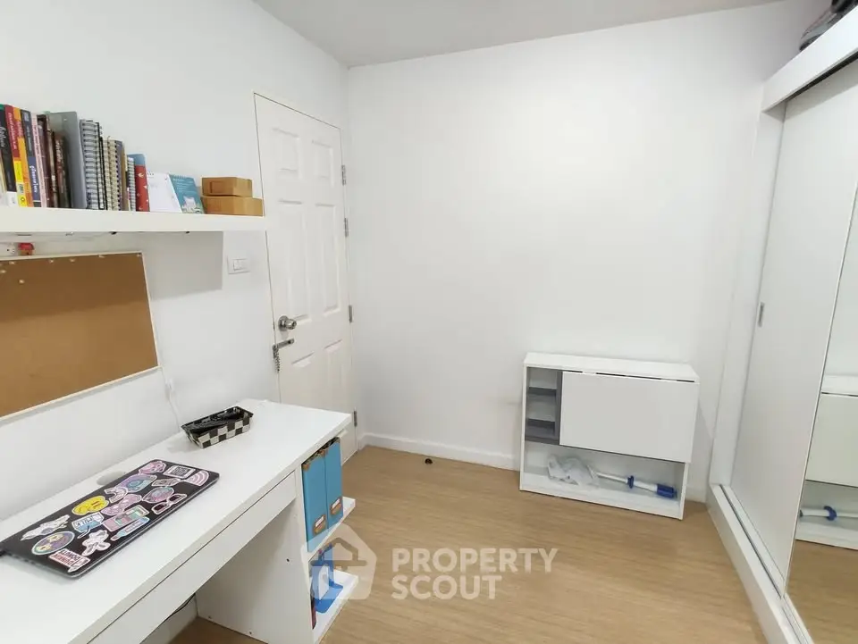 Modern study room with sleek white furniture and ample storage space
