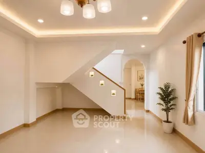 Spacious modern living room with elegant staircase and natural light