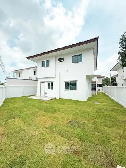Spacious two-story white house with lush green lawn and modern design