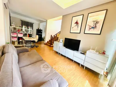 Spacious living room with modern decor and ample natural light, featuring a cozy sofa and stylish storage solutions.