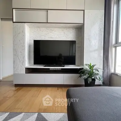 Modern living room with sleek TV unit and natural light