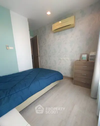 Cozy bedroom with modern decor and air conditioning, perfect for relaxation.