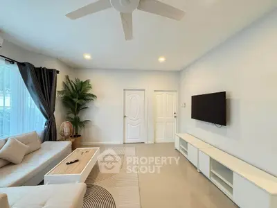 Modern living room with sleek furniture and wall-mounted TV, perfect for relaxation.