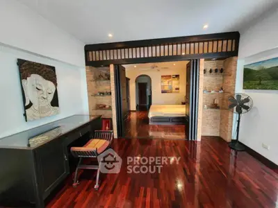 Spacious living room with wooden flooring and artistic decor, perfect for modern living.