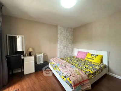 Cozy bedroom with stylish decor and wooden flooring, featuring a comfortable bed and a modern vanity desk.