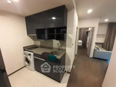 Modern kitchen with sleek cabinets and washing machine in stylish apartment