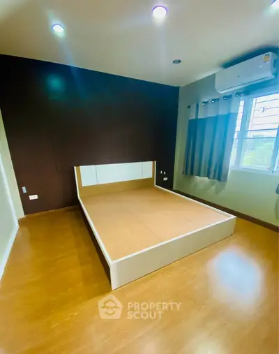 Spacious bedroom with modern design and large window for natural light.