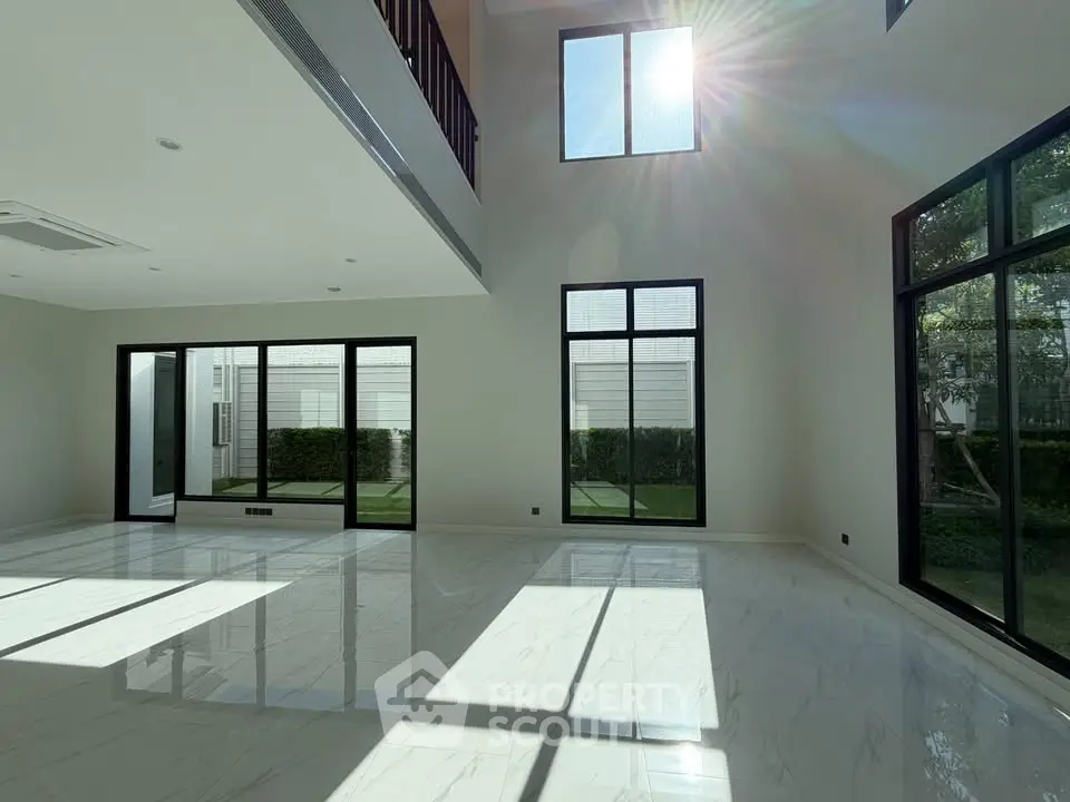 Spacious modern living room with high ceilings and large windows offering abundant natural light.