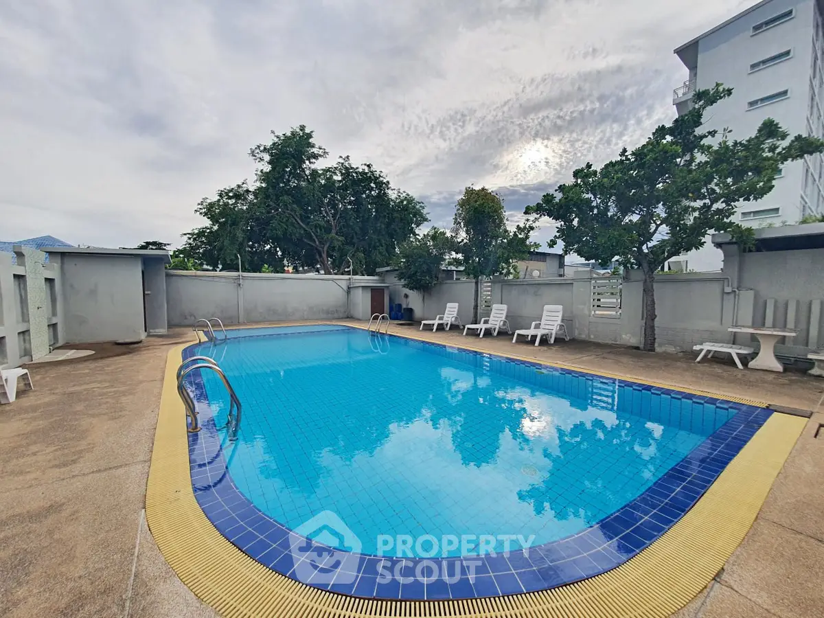 Stunning outdoor pool area with serene surroundings and ample seating, perfect for relaxation and leisure.