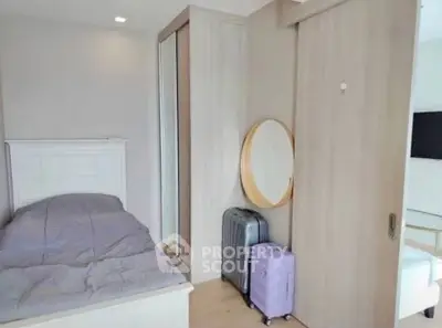 Cozy bedroom with modern decor and mirrored wardrobe, perfect for urban living.