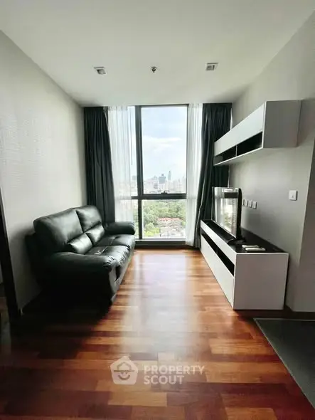 Modern living room with city view, sleek furniture, and hardwood floors.