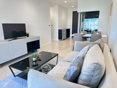 Modern living room with sleek furniture and large TV in a stylish apartment.